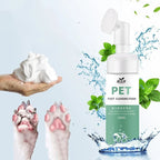 Pet foot cleansing foam bottle with foam in hand, clean and dirty dog paws, mint leaves, and water.