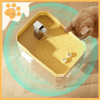 Orange cat drinks from yellow interactive pet water fountain on wooden floor
