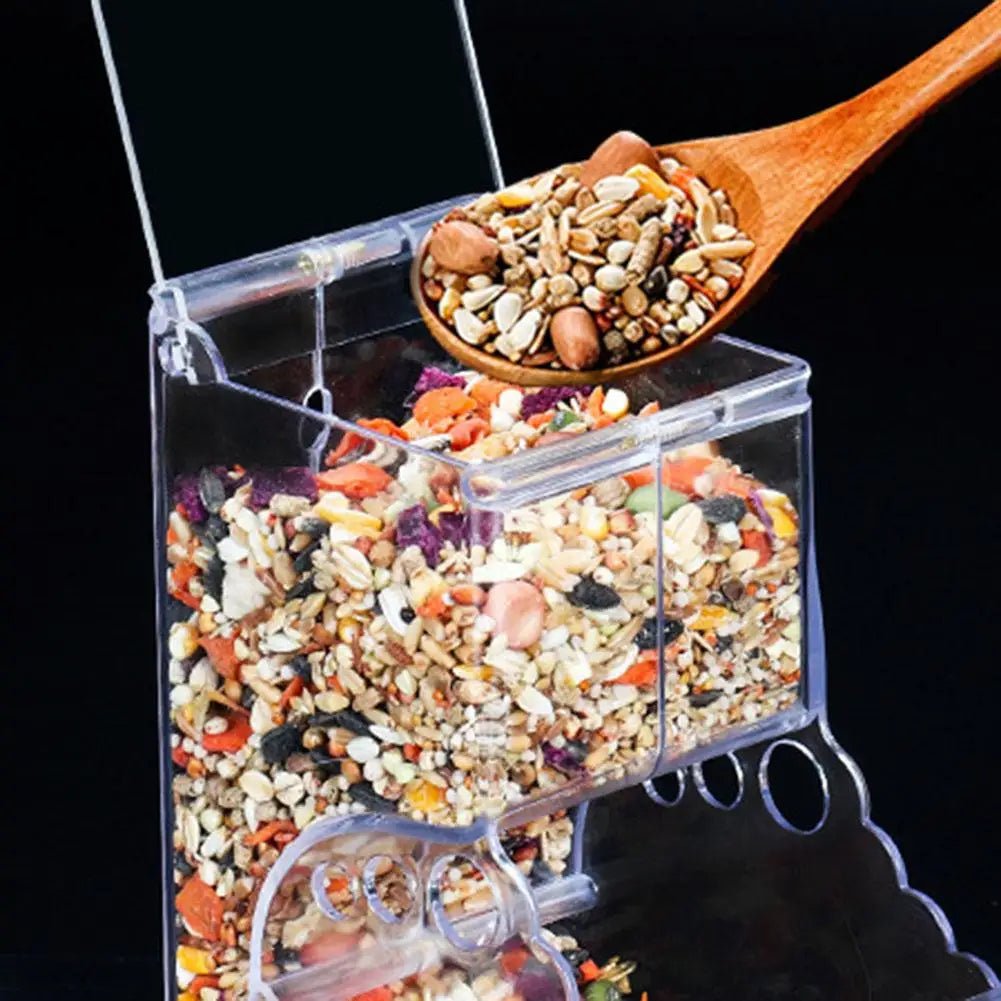 Clear plastic seed dispenser full of mixed bird seed, wooden spoon scooping seeds