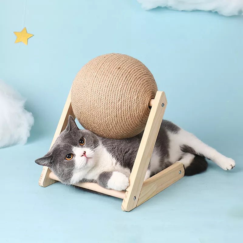 Gray and white cat lying under a sisal rope cat scratcher in a blue room with cloud decor.