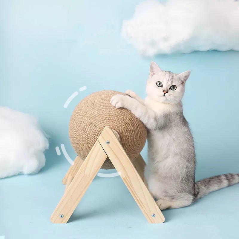 Gray cat with scratching post on wood stand against blue background with fluffy clouds