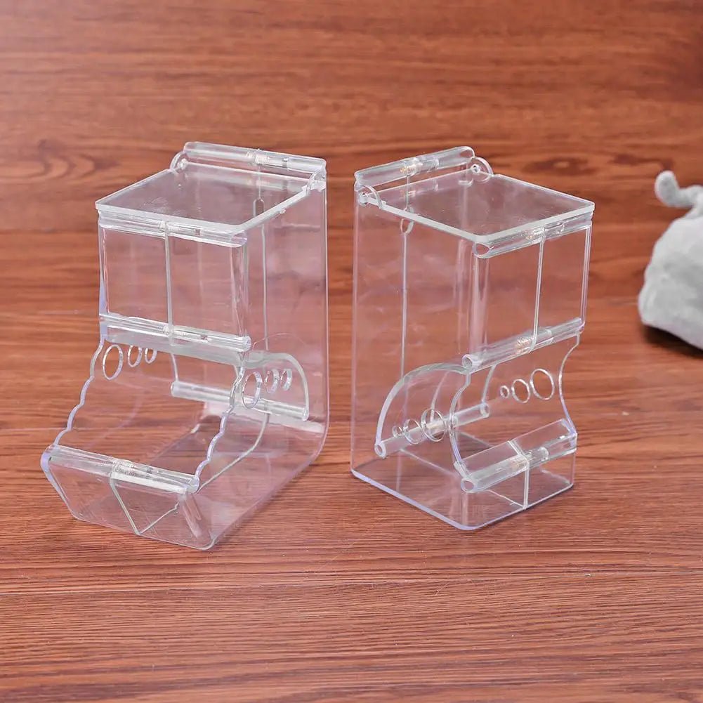 Two clear plastic bird feeders on a wooden surface