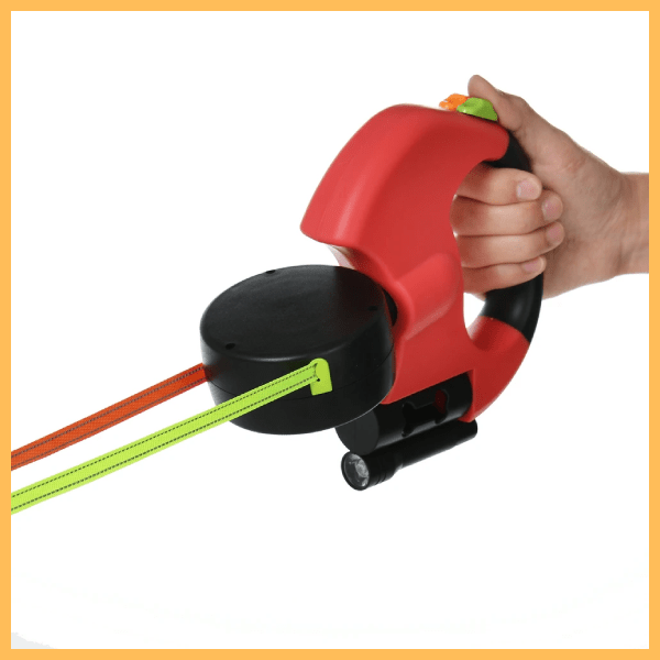 Red dual dog leash with LED light, ergonomic handle, and two retractable leads in hand