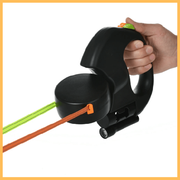 Black dual dog leash with flashlight, orange and green leads, handheld use demonstration