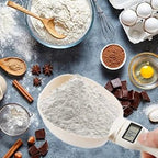 Digital measuring scoop weighing flour with baking ingredients like eggs, chocolate, spices on table