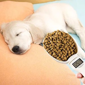 Sleeping puppy beside a digital pet food scoop filled with dry dog kibble