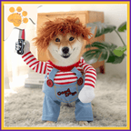 Shiba Inu in Chucky costume with red wig, striped shirt, and overalls holding toy knife indoors