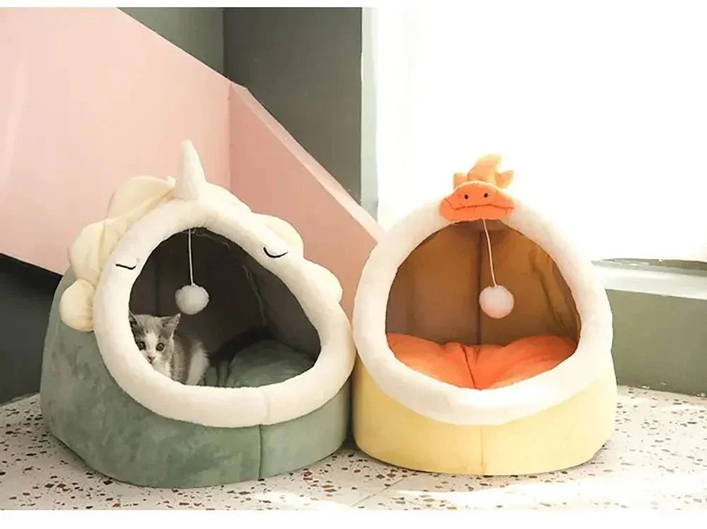 Cute cat in plush unicorn cat bed beside yellow duck pet bed in sunlit room