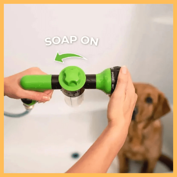 Person using green AquaPet Jet with soap control feature, dog in background, bath setting