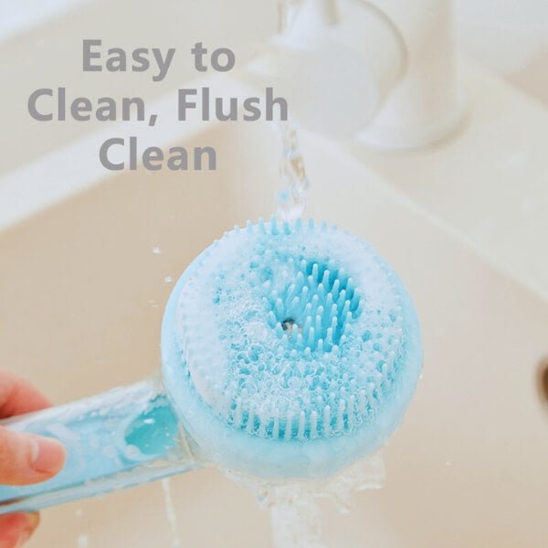 Blue pet bath brush being rinsed under running water in a sink, easy to clean