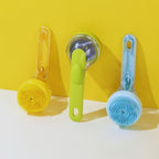 Yellow, green, and blue silicone pet bath brushes with handles against a yellow background.