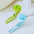 Green and blue pet bath brushes with silicone bristles on a bathroom counter