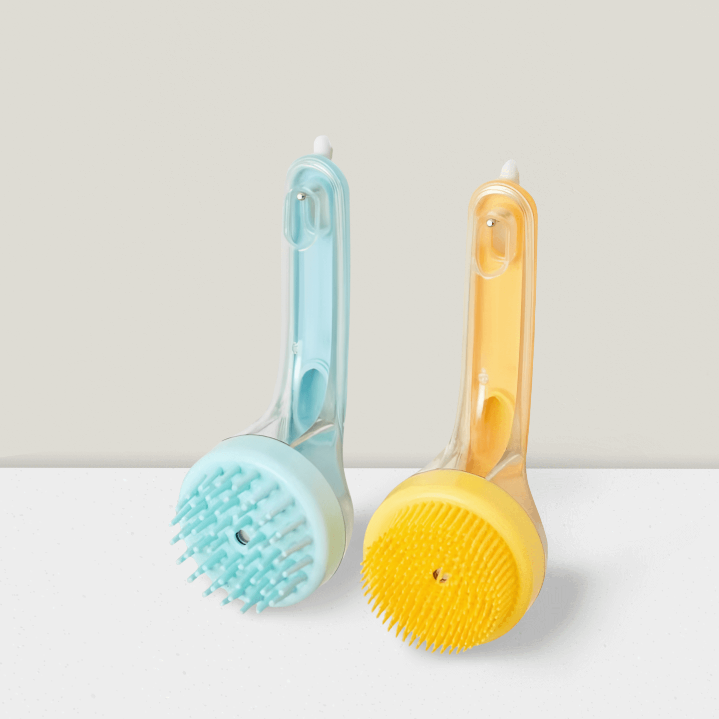 Blue and yellow pet bath brushes with silicone bristles on a white surface