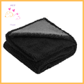 Folded black waterproof dog blanket with soft texture on white background