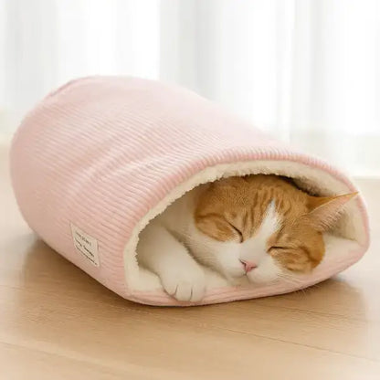 Furry cat resting inside soft pink sleeping bag bed