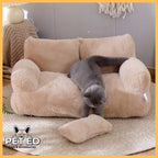 Grey cat on plush beige pet sofa bed with cushion in cozy indoor room