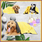 Dogs wrapped in yellow microfiber towels at a spa setting with candles, stones, and leaves