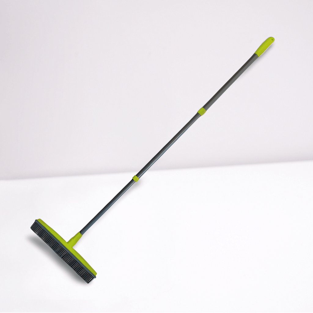 Green silicone broom with long handle on a white background