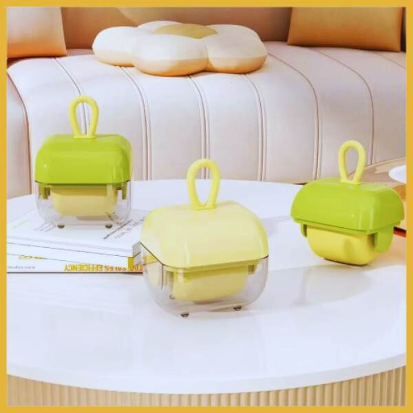 Cute mini hair rollers in yellow and green cases on a white table, cozy sofa background
