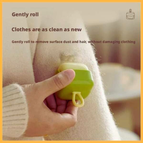 Hand using a green portable pet hair remover roller on a beige sweater