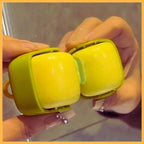 Hands holding a yellow and green mini washable hair roller near a mirror