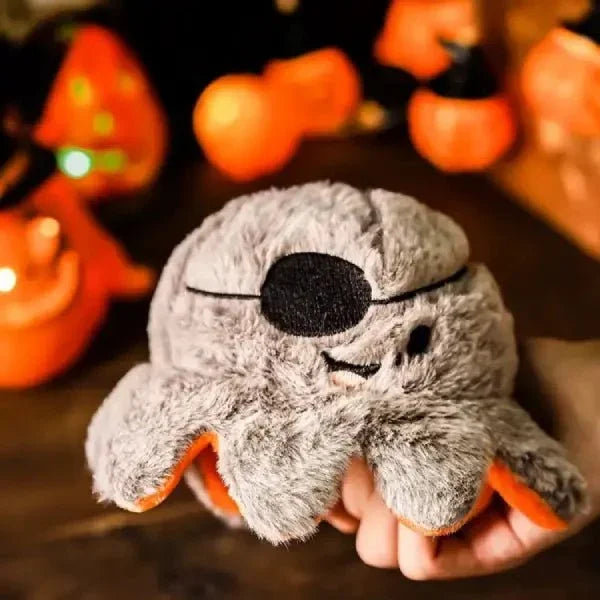 Halloween dog toy pirate octopus side held in hand, with blurred Halloween lights in the background