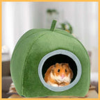 Happy hamster sitting in a green plush nest house for small pets
