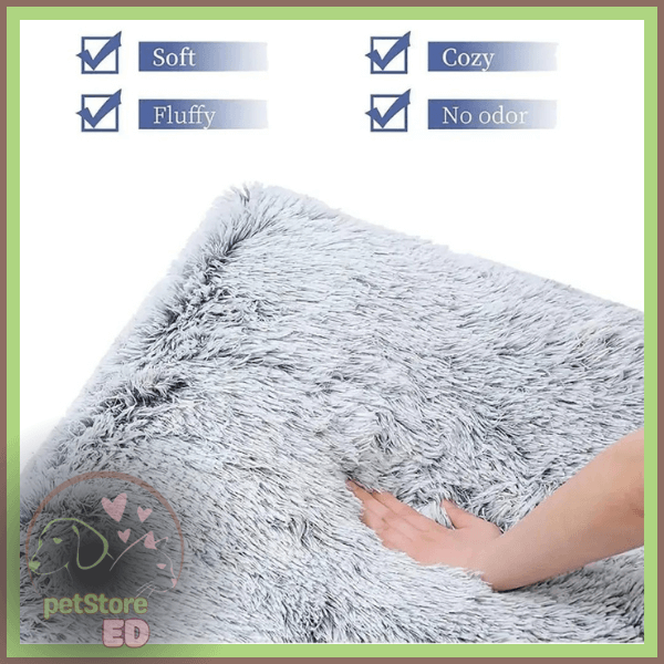 Hand touching soft fluffy gray orthopedic pet bed with cozy, no odor, washable features.