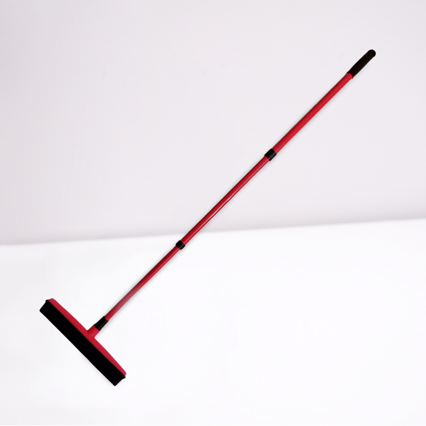 Red silicone broom with long handle for pet hair on white background