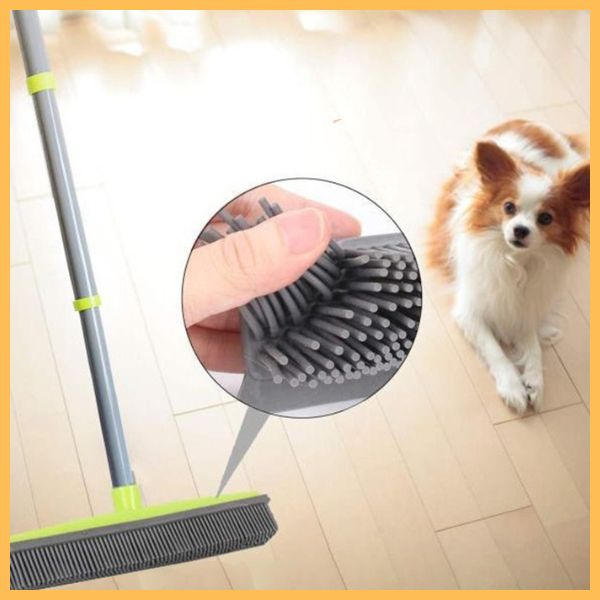 Silicone broom cleaning pet hair on hardwood floor with dog nearby, close-up bristles inset