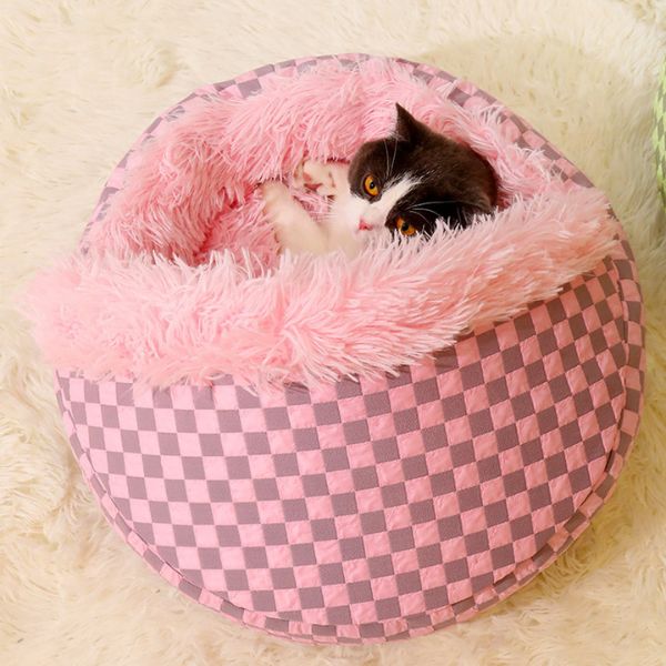 Cat playing in a soft pink checkered pet bed on a cream furry rug