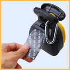 Hand pulling waste bag from dog poop scooper with dispenser and carabiner