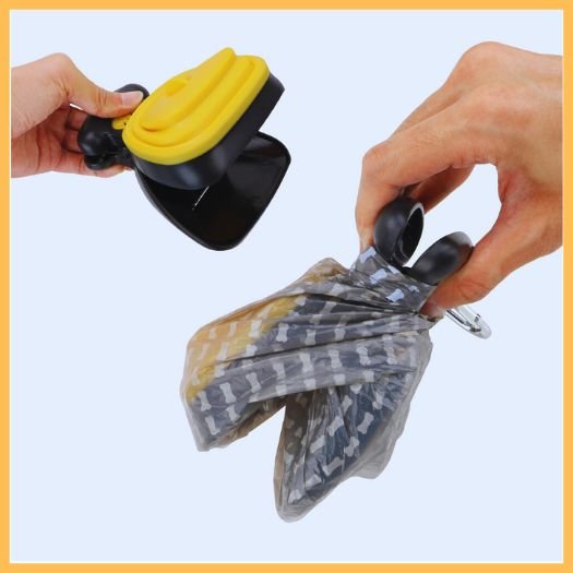 Hands placing waste bag on portable dog poop scooper against a light background