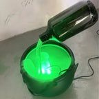 Close-up of the potion bottle pouring green mist into the witches cauldron's water reservoir