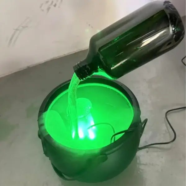 Close-up of the potion bottle pouring green mist into the witches cauldron's water reservoir